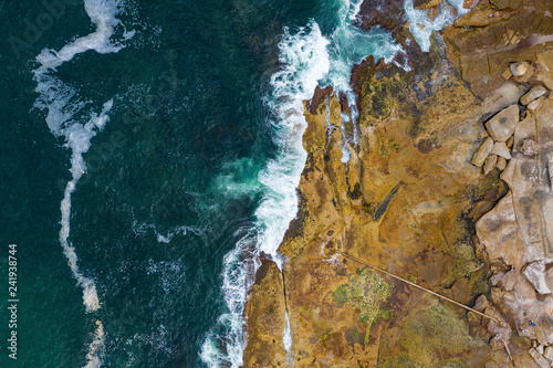 Photography Aerial, overhead view of waves and a rocky shoreline