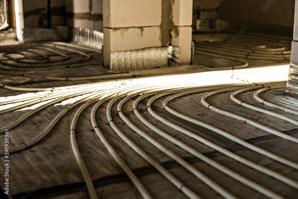 The process of installation of heat flooring in a new building house. Modern radiant underfloor heating system The process of installation of heat flooring in a new building house. Modern radiant underfloor heating system