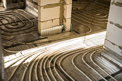 The process of installation of heat flooring in a new building house. Modern radiant underfloor heating system photo