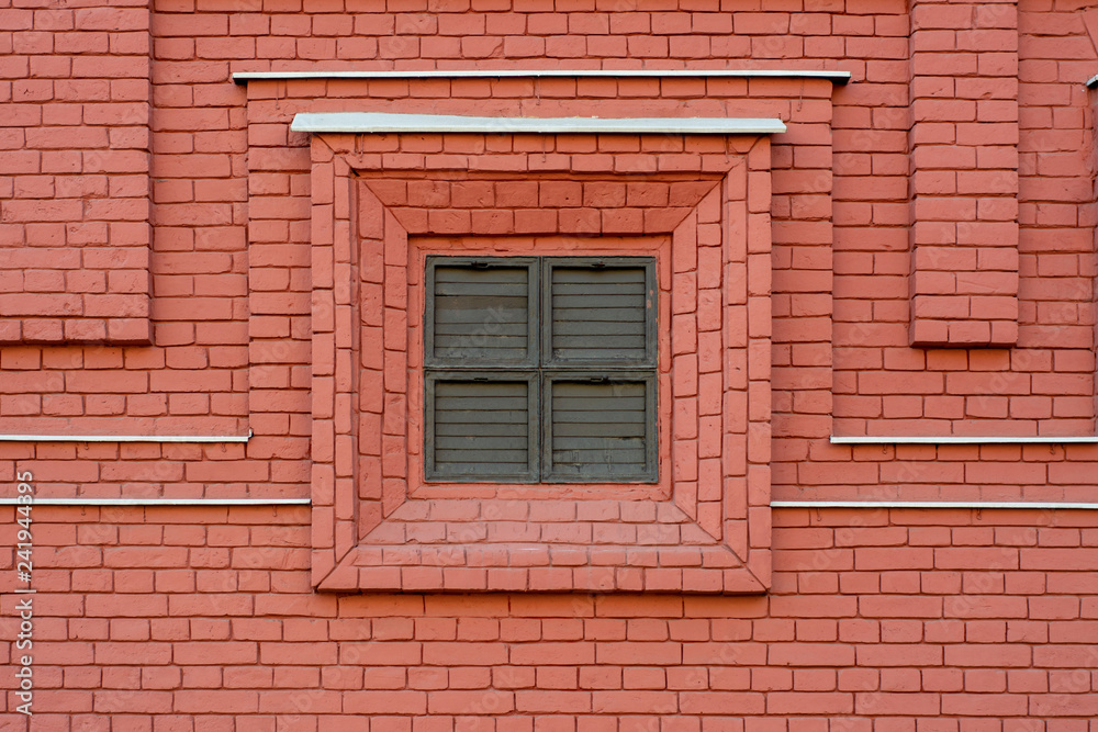 Shuttered window in decorative brick wall