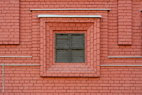 Shuttered window in decorative brick wall