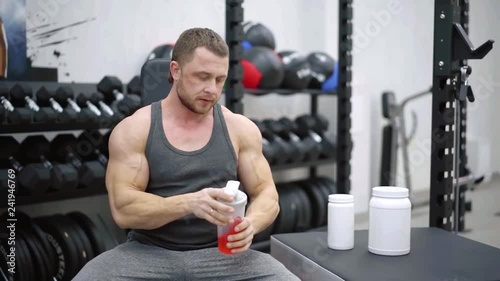 professional sportsman is cooking cocktails with protein in a training room, sitting photo