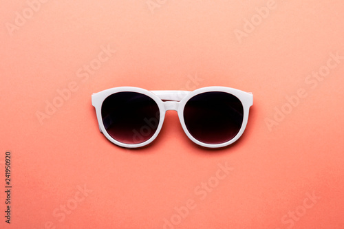 Women's sunglasses in white rim on living coral background