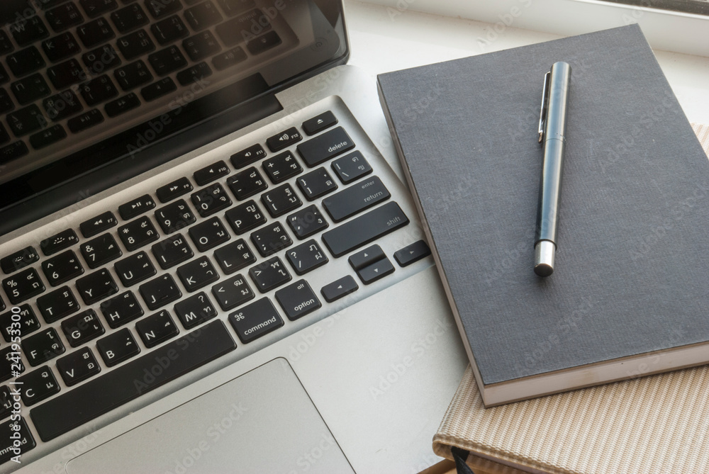 Laptop workspace with notebooks and pens Laptop workspace with notebooks and pens