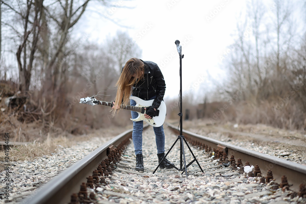 Εκτύπωση καμβά A rock musician girl in a leather jacket with a guitar