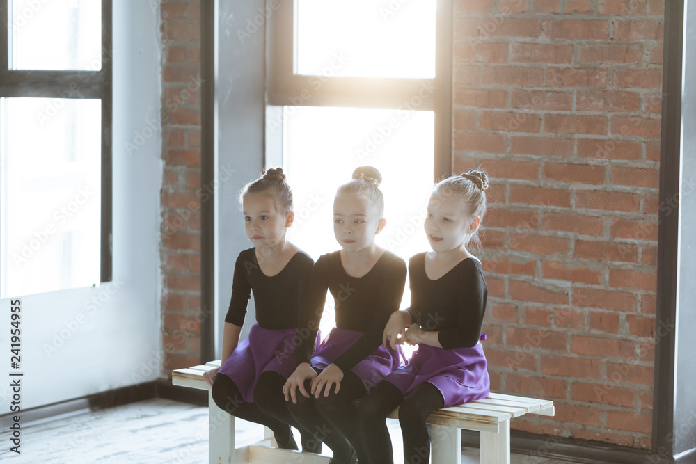 Cute little kids dancers on dance studio. Choreographed dance by a group of small ballerinas practicing at a modern ballet school