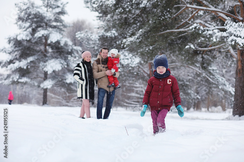 Young family with children are walking in the winter park. Winter walk of parents with children. Walking on a holiday weekend in the winter.