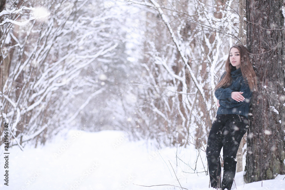 Girl in a winter park in snowfall Girl in a winter park in snowfall