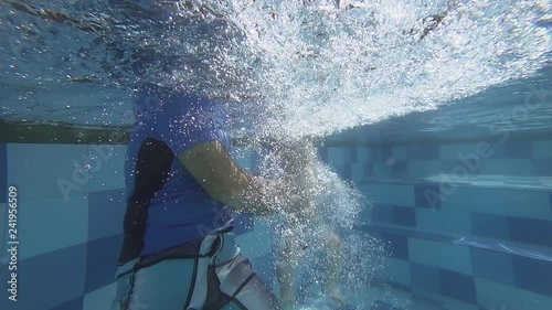 Happy smiling toddler is diving under water with father
