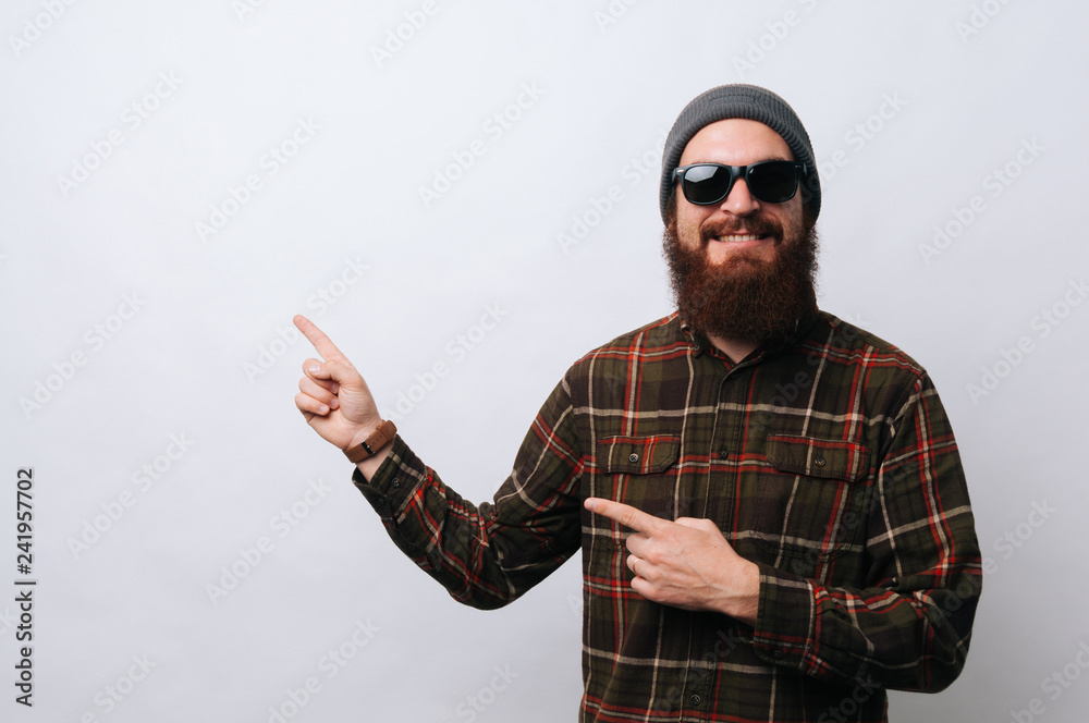 Photo of bearded man pointing to left, over white background Photo of bearded man pointing to left, over white background