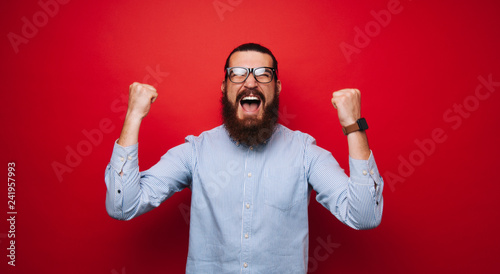 Portrait of screaming man, celebrating his victory and gesturing with fists up photo