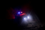 Police car chasing a car at night with fog background. 911 Emergency response police car speeding to scene of crime.