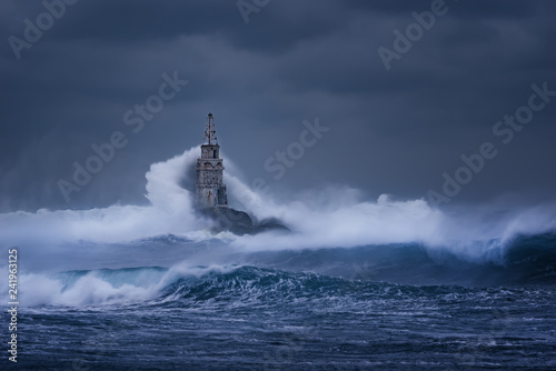 Fototapeta Naklejka Na Ścianę i Meble -  Big wave against old Lighthouse in the port of Ahtopol, Black Sea, Bulgaria on a moody stormy day. Danger, dramatic scene.