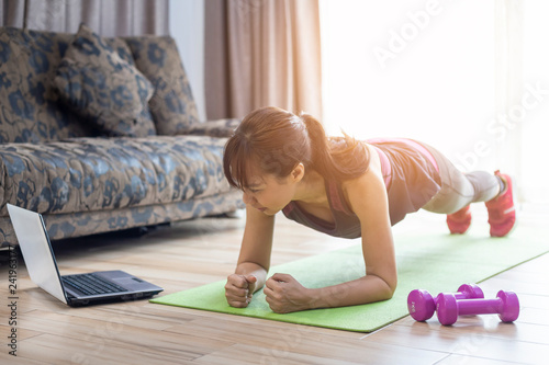 Asian women are exercising at home, female doing planking exercise indoor