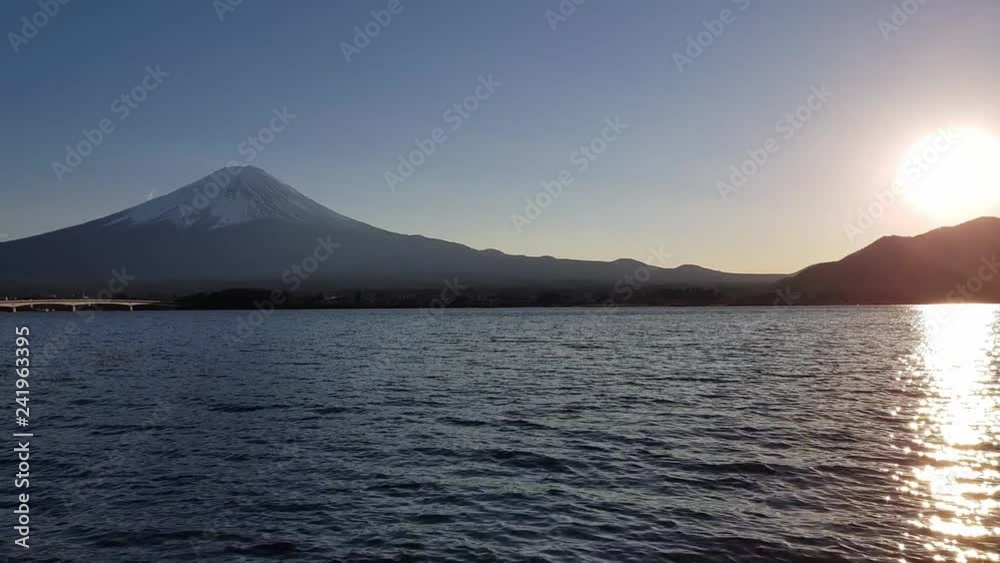 Panning views of Mt. Fuji and Lake Kawaguchi with the low evening sun the same height as the mountain's peak Panning views of Mt. Fuji and Lake Kawaguchi with the low evening sun the same height as the mountain's peak