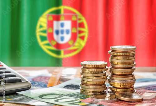 Geldscheine und Münzen vor der Nationalflagge Portugals photo