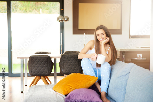 Young woman relaxing on sofa early morning
