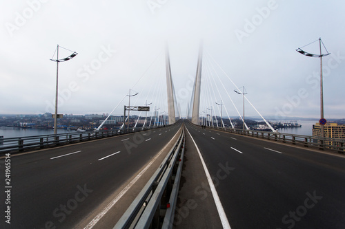 Golden cable-stayed bridge road car traffic from above. Modern Vladivostok Russia night illumination. Old and modern central buildings. 