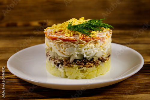 Traditional russian salad Mimosa on wooden table