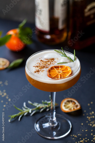 фотографія Christmas cocktail of amaretto sour with dehydrated clementine and rosemary