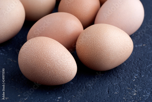 Eggs of guinea fowl on blue background closeup