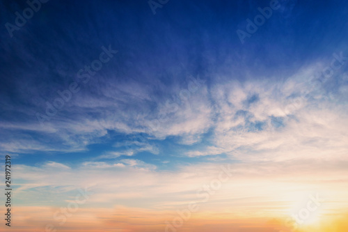 Sky blue and orange light of the sun through the clouds in the sky