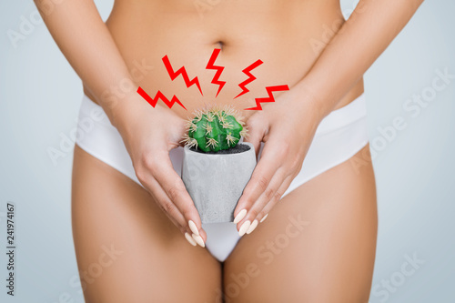 Woman holding spiny cactus near her genitals