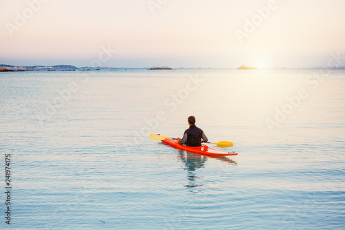 Kajak Fahrer padelt ins Meer hinaus bei Sonnenuntergang