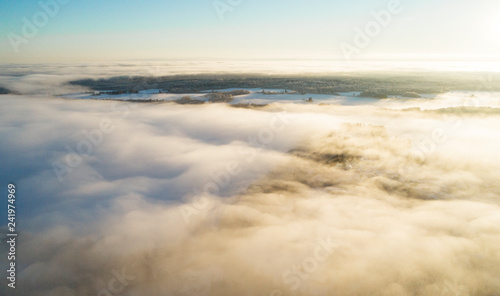 Aerial view clouds over forest during winter colours. Aerial view of forest and clouds. Aerial drone view of the forest. Aerial top view cloudscape. Texture of clouds.