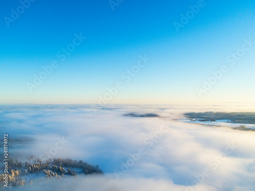 Aerial view clouds over forest during winter colours. Aerial view of forest and clouds. Aerial drone view of the forest. Aerial top view cloudscape. Texture of clouds.