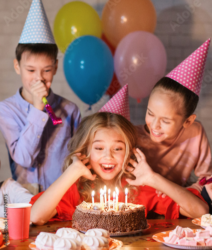 Happy girl in party hat with birthday cake