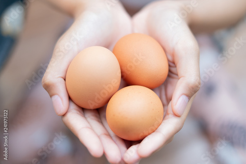 Close up of women holding chicken eggs.