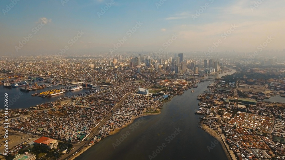 Obraz premium Aerial view skyline of Manila city, Makati. Fly over city with skyscrapers and buildings. Aerial skyline of Manila. Modern city by sea, highway, cars, skyscrapers, shopping malls. Travel concept.