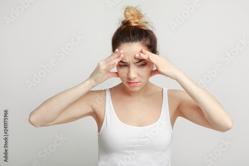 Принти на полотні Exhausted woman suffering from headache over gray background