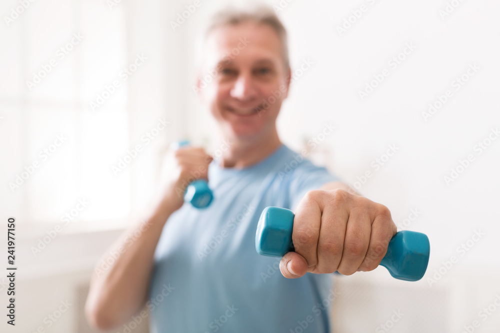 Mature man exercising with dumbbells at home Mature man exercising with dumbbells at home