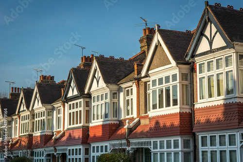 Row of typical British homes against a clear blue sky