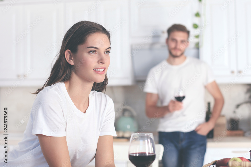Pretty young woman drinking some wine at home in kitchen. Pretty young woman drinking some wine at home in kitchen.