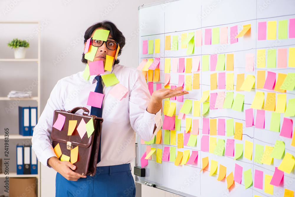 Young employee in conflicting priorities concept 