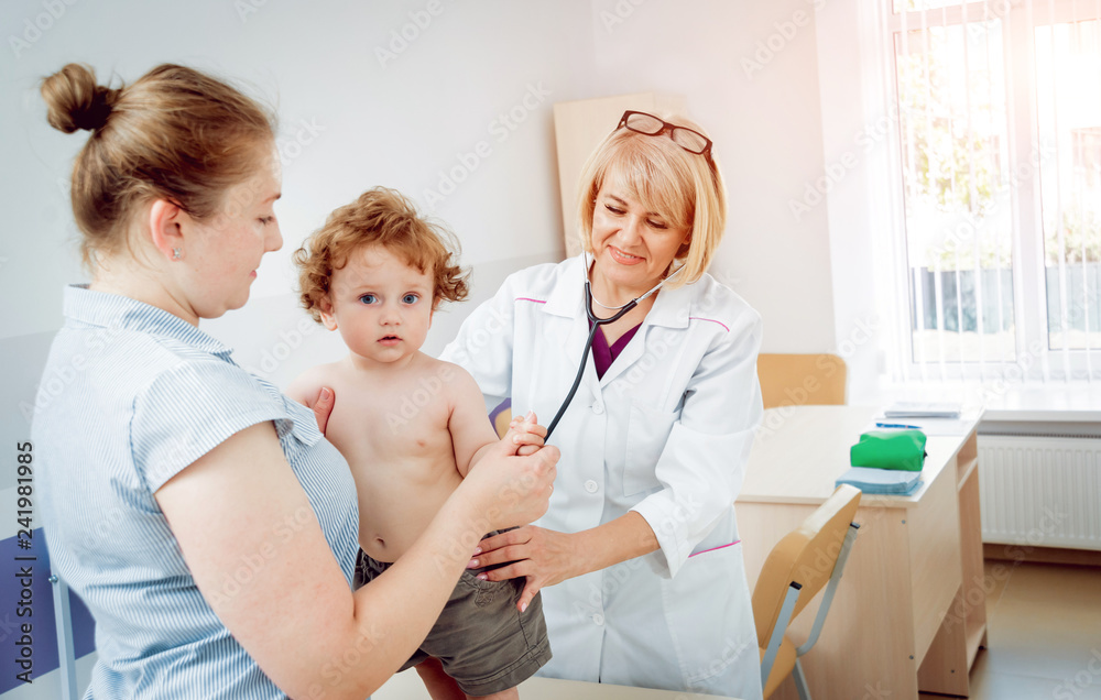 Friendly doctor pediatrician with patient child at clinic