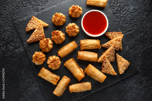 Crispy Chicken wontons, vegetable spring rolls and prawn toasts with sweet chilli sauce. chinese selection. fast food.