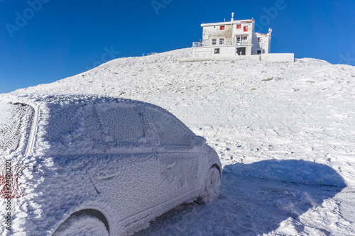 Winter landscape of the shelter of Velouchi mountain in Karpenissi, Evritania, Greece. A frozen car outside the shelter