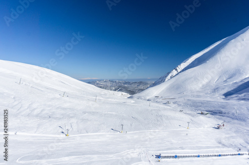 Winter landscape of an empty snow covered ski resort in the mountains.