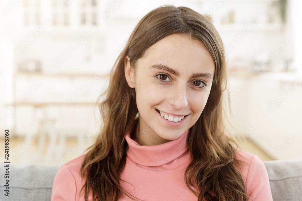 Closeup headshot of positive young lady spending free afternoon at home