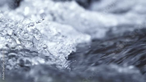 Winter waterfall river close up in slow motion. Crystal water in the mountains.