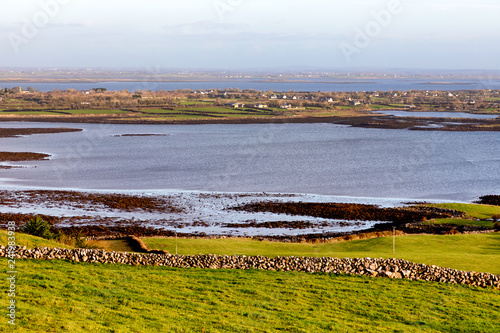 Farms in the Burren with Galway bay in background photo