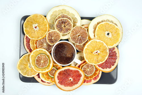 Black coffee in a white Cup surrounded by citrus dried fruits