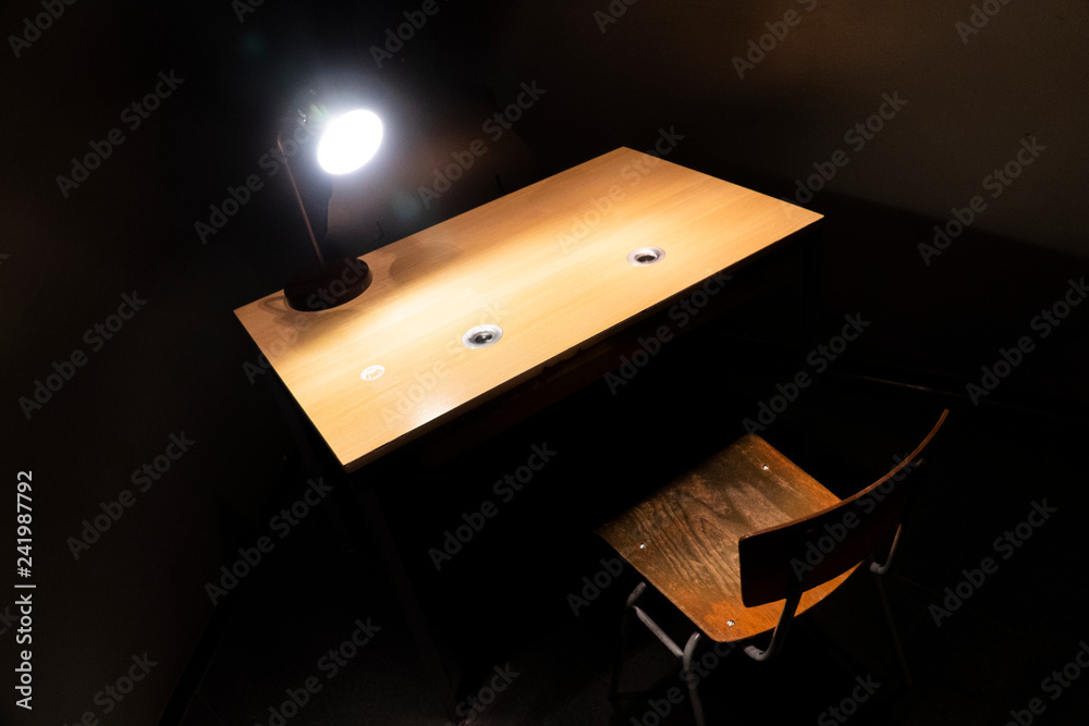 Interrogation room with a bright lamp on the table and one chair. Stock  Photo | Adobe Stock