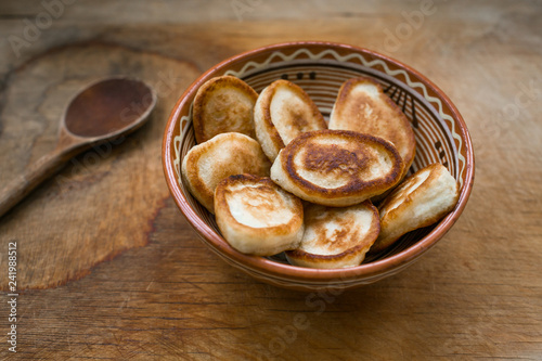 Russian Fried Fritters, ceramic bowl, wooden background, retro style