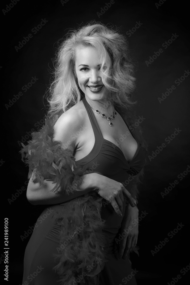 Attractive middle age woman in evening dress with fluffy feather boa.