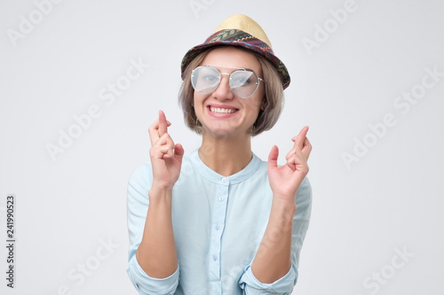 Girl in hat and summer glasses having excited, superstitious and naive look photo